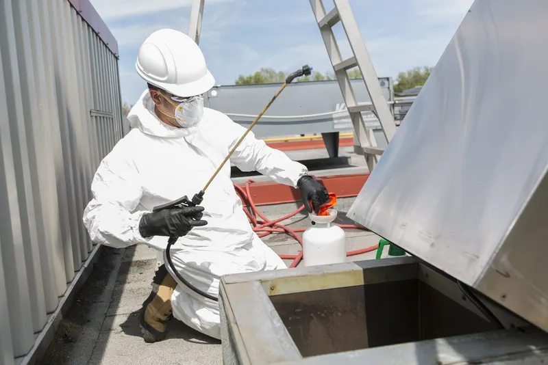 Rooftop upblast exhaust fan on a flat commercial roof, mounted on its curb above a restaurant kitchen